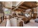 Open-concept living room with wood beams, stone fireplace, and views to the kitchen, breakfast bar, and dining room at 23 Verde Ct, Breckenridge, CO 80424