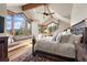 Light-filled main bedroom features vaulted ceilings, wooden beams, a window seat and mountain views at 23 Verde Ct, Breckenridge, CO 80424