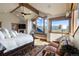 Light-filled main bedroom features vaulted ceilings, wooden beams, a window seat and mountain views at 23 Verde Ct, Breckenridge, CO 80424