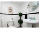 This charming bathroom features white subway tiles, black accent stripes, and an 'Oh Happy Day' wall decor at 675 S University Blvd # 106, Denver, CO 80209