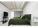 Bedroom featuring ceiling beams, a cozy bed, and ample space for a relaxing retreat at 675 S University Blvd # 106, Denver, CO 80209