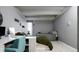 This bedroom features neutral gray walls, wooden floors, a comfortable bed, and a well-lit desk area for work or study at 675 S University Blvd # 106, Denver, CO 80209