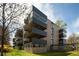 Multi-story building featuring balconies, well-kept lawns, and mature trees at 675 S University Blvd # 106, Denver, CO 80209