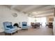 Inviting living area with light blue armchairs, fireplace, white brick wall, and adjacent dining space at 675 S University Blvd # 106, Denver, CO 80209