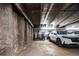 This parking garage with visible structure elements and recessed lighting has ample spots for a variety of vehicles at 675 S University Blvd # 106, Denver, CO 80209