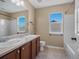 Bathroom with a double sink vanity, a tub and a large window at 11545 S Flower Mound Way, Parker, CO 80134
