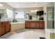 Bright and airy bathroom with large tub, vanity with cabinets, large mirror, and a glass-door shower at 11545 S Flower Mound Way, Parker, CO 80134