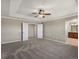 Main bedroom with tray ceiling, double door closet, and view into the bathroom at 11545 S Flower Mound Way, Parker, CO 80134
