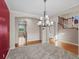 Elegant dining room featuring hardwood floors, modern chandelier, and staircase at 11545 S Flower Mound Way, Parker, CO 80134