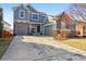 Charming two-story home with gray exterior, brick accents, and a spacious driveway at 11545 S Flower Mound Way, Parker, CO 80134