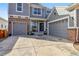 Charming two-story home with a gray exterior, brick accents and a large driveway at 11545 S Flower Mound Way, Parker, CO 80134