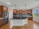 Modern kitchen island features a sink, dark countertops, and wood cabinets at 11545 S Flower Mound Way, Parker, CO 80134