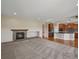 Open-concept living room with hardwood floors, stone fireplace, and a large kitchen with dark wood cabinets at 11545 S Flower Mound Way, Parker, CO 80134