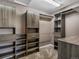 Organized walk-in closet with wooden shelves, drawers, and hanging rods for ample storage at 11545 S Flower Mound Way, Parker, CO 80134