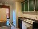 Functional kitchen area with classic appliances, tile countertops, and vintage green cabinets at 1337 Valentia St, Denver, CO 80220