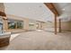 Open basement area with a fireplace, wooden beam accents, and a nearby game room with a pool table at 91 Hess Ave, Golden, CO 80401