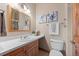 Well-lit bathroom with a wood vanity, white countertop, modern fixtures, and decorative floral artwork at 91 Hess Ave, Golden, CO 80401