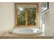 Luxurious soaking tub by a large window offering a serene view of the surrounding greenery at 91 Hess Ave, Golden, CO 80401