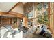 Bright living room with a stone fireplace, wooden beams, and large windows overlooking trees at 91 Hess Ave, Golden, CO 80401