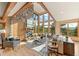 Open living room with stone fireplace, wood beams, large windows, and comfortable seating at 91 Hess Ave, Golden, CO 80401