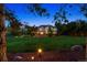 Large grassy backyard with mature trees, exterior home view, and landscape lighting at 3970 White Bay Dr, Highlands Ranch, CO 80126