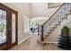 Grand foyer with hardwood floors, decorative front door, and a curved staircase with iron railings at 3970 White Bay Dr, Highlands Ranch, CO 80126