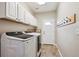 Laundry room with white cabinets, tile floors and washer and dryer included at 3970 White Bay Dr, Highlands Ranch, CO 80126