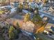 An aerial view of a large, fenced backyard and an updated home with a red-toned roof and mature trees at 8258 W 66Th Dr, Arvada, CO 80004