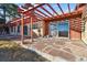 Back patio with stone floors and pergola adjacent to sliding glass door at 8258 W 66Th Dr, Arvada, CO 80004