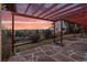 This back patio features a pergola with sunset views and a stone tile floor, ideal for outdoor entertaining at 8258 W 66Th Dr, Arvada, CO 80004