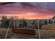 Backyard view featuring a swing and colorful sunset at 8258 W 66Th Dr, Arvada, CO 80004