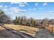 Large sloping yard with wooden fence and treeline at 8258 W 66Th Dr, Arvada, CO 80004