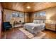 Bedroom with wood ceiling and walls with a large bed, bright windows, and built-in shelving at 8258 W 66Th Dr, Arvada, CO 80004