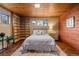 Charming bedroom with wood ceiling, walls, terracotta floors, and a cozy rug at 8258 W 66Th Dr, Arvada, CO 80004