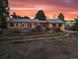 Back exterior view of the home with terraced yard at sunset at 8258 W 66Th Dr, Arvada, CO 80004