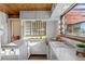 A retro kitchen design features white cabinets, vintage appliances, an adjacent dining area, and abundant natural light at 8258 W 66Th Dr, Arvada, CO 80004