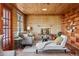 Cozy sunroom living room with a brick fireplace and built-in shelving at 8258 W 66Th Dr, Arvada, CO 80004