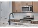 Modern kitchen featuring stainless steel appliances, granite counters, stylish backsplash, and dark bronze faucet at 16774 W 93Rd Pl, Arvada, CO 80007