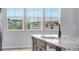 Kitchen island features granite countertop, undermount sink, and modern faucet with views from the three windows at 16774 W 93Rd Pl, Arvada, CO 80007