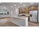 Modern kitchen features stainless steel appliances, a center island, and wood floors at 16774 W 93Rd Pl, Arvada, CO 80007