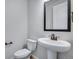 A cozy powder room with a pedestal sink, bronze faucet, and fixtures next to the toilet at 16774 W 93Rd Pl, Arvada, CO 80007