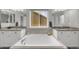 Bright bathroom features a soaking tub, granite countertops, and dual sinks at 17052 Lipan St, Broomfield, CO 80023