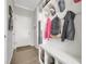 Inviting entryway with a white door, bench, hooks, and storage near the kitchen at 17052 Lipan St, Broomfield, CO 80023