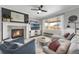 Cozy living room with a fireplace, comfortable seating, a ceiling fan, and backyard views at 17052 Lipan St, Broomfield, CO 80023