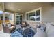 Covered patio boasts seating, side tables and stone accents, enhancing the outdoor living experience at 17052 Lipan St, Broomfield, CO 80023