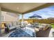 Covered patio includes comfortable seating, a grill and outdoor dining table, ideal for entertaining at 17052 Lipan St, Broomfield, CO 80023