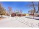 View of the house from the backyard, covered in snow at 12152 E Dakota Ave, Aurora, CO 80012