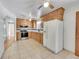 Kitchen with wood cabinets, granite counters, and appliances at 12152 E Dakota Ave, Aurora, CO 80012