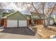 Charming two-story home with a two-car garage, green siding, and a brick facade, showcasing curb appeal at 1922 Lydia Dr # 82, Lafayette, CO 80026