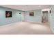 Large basement area featuring neutral carpeting, soft blue wall color, and access to additional rooms at 9925 W Progress Pl, Littleton, CO 80123